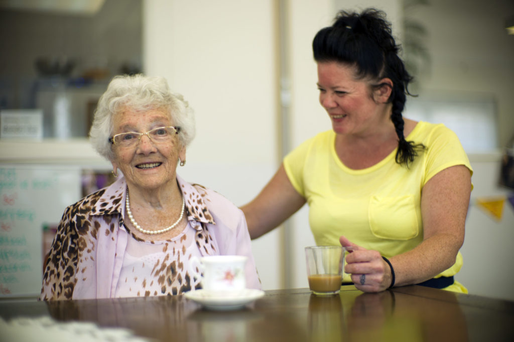 Twee lachende mensen drinken samen koffie met elkaar