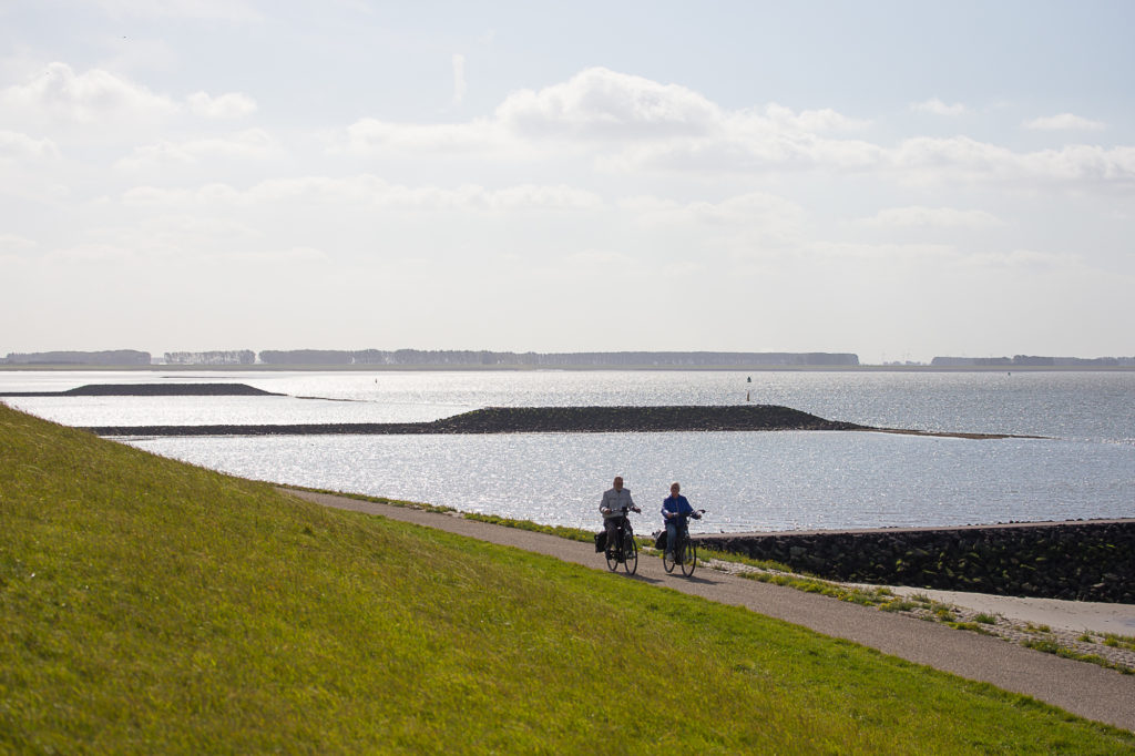 Twee senioren fietsen langs de Westerschelde