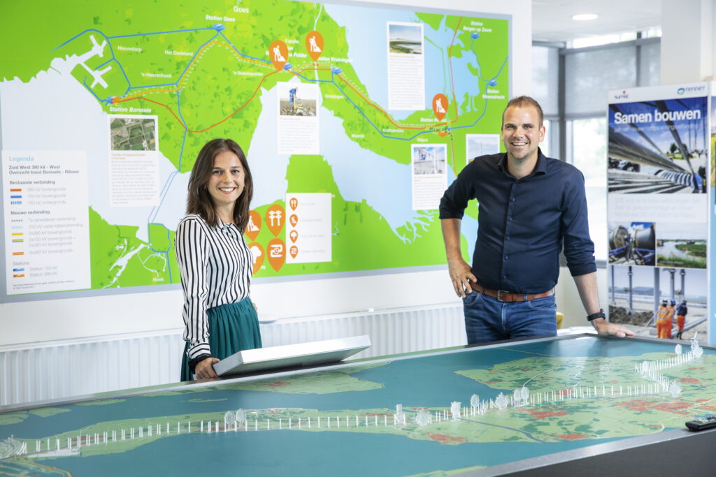 Een foto van twee werknemers van Lievens in een informatiecentrum van TenneT
