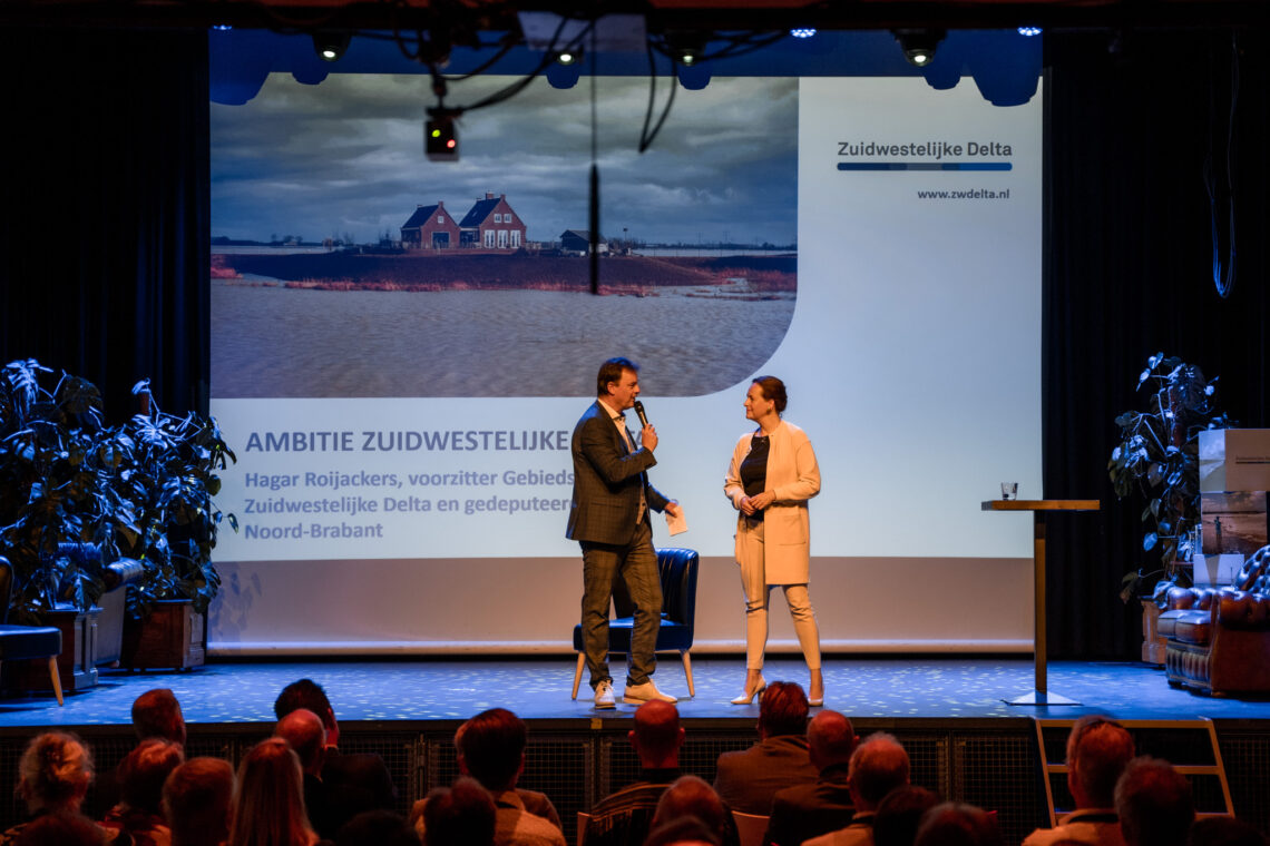 Een man en een vrouw op het podium praten over de ambitie van de Zuidwestelijke Delta.