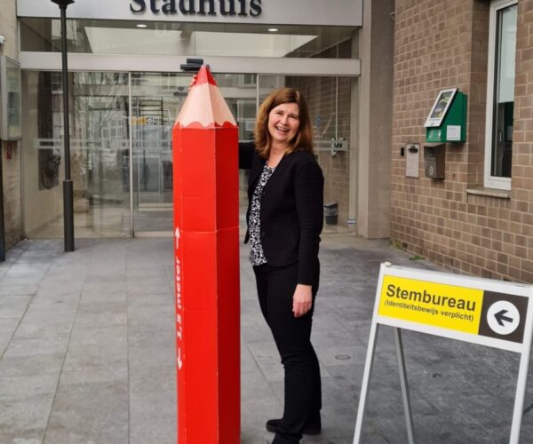 Anneloes met een grote versie van het rode stempotlood voor het stadhuis in Hulst