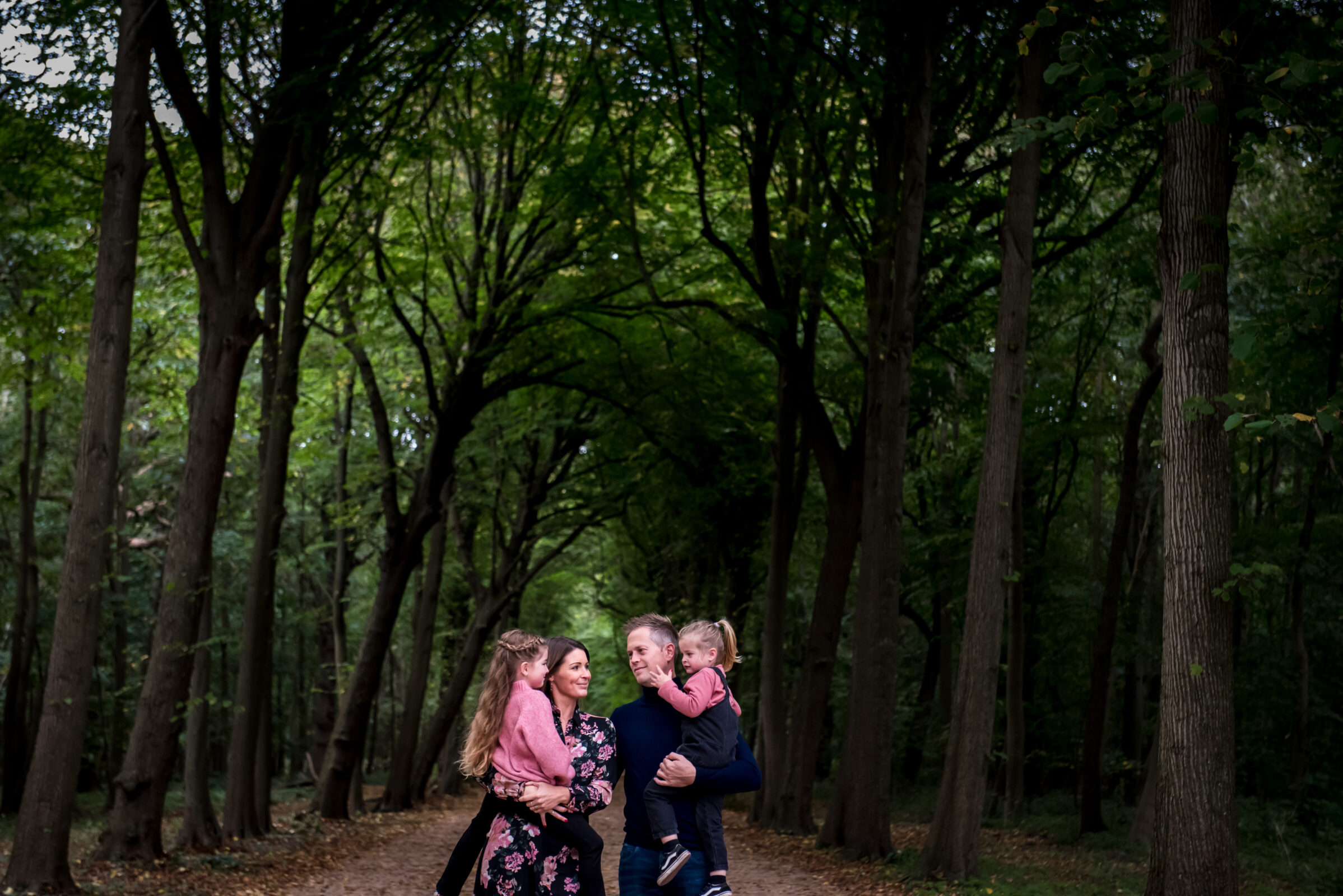 Gezin met man en vrouw en twee kinderen in het bos in Zeeland.