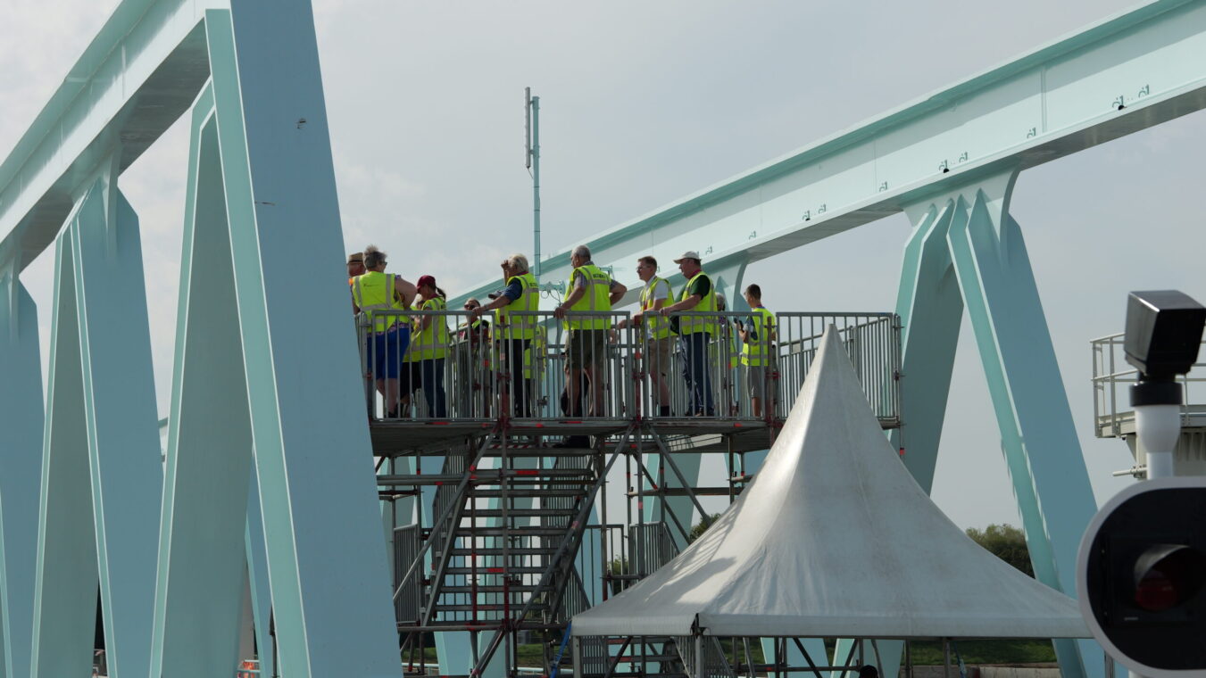 Mensen in gele hesjes staan op een uitkijkplatform bij de Nieuwe Sluis Terneuzen