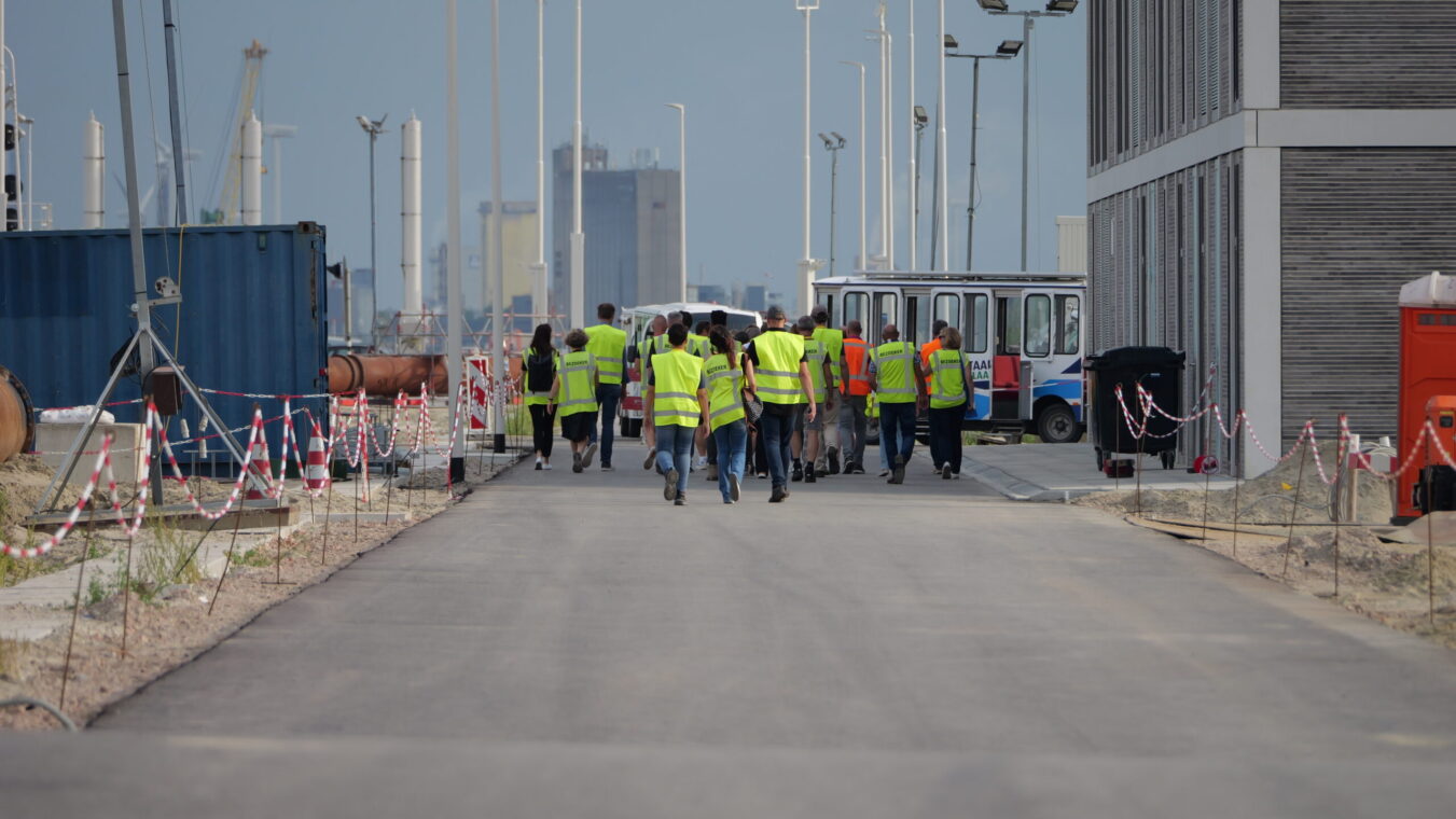 Mensen in gele hesjes lopen over het bouwterrein van de Nieuwe Sluis Terneuzen