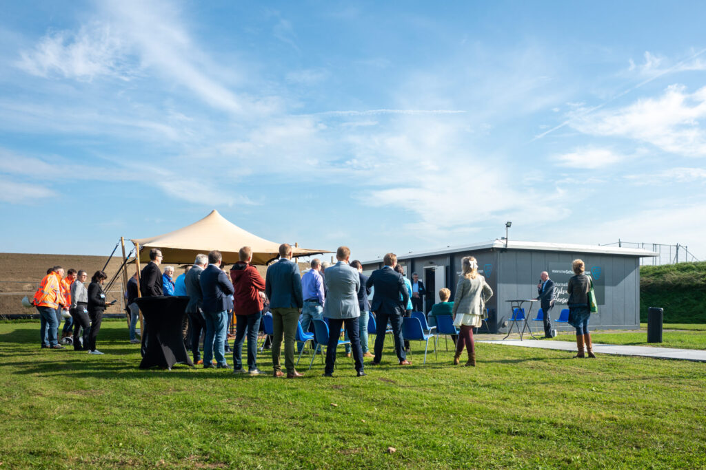 Groep met mensen bij de opening van het informatiecentrum voor de dijkversterking bij Hansweert