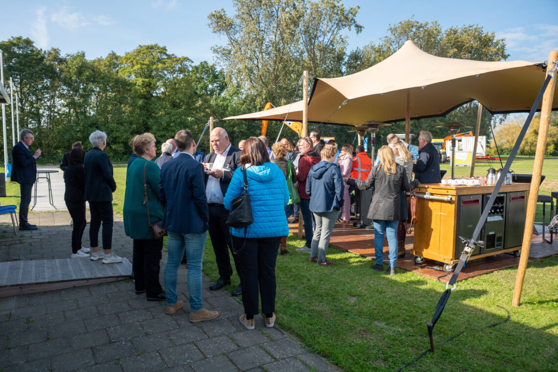 Bezoekers drinken koffie met elkaar na de opening van het informatiecentrum voor de Dijkversterking bij Hansweert